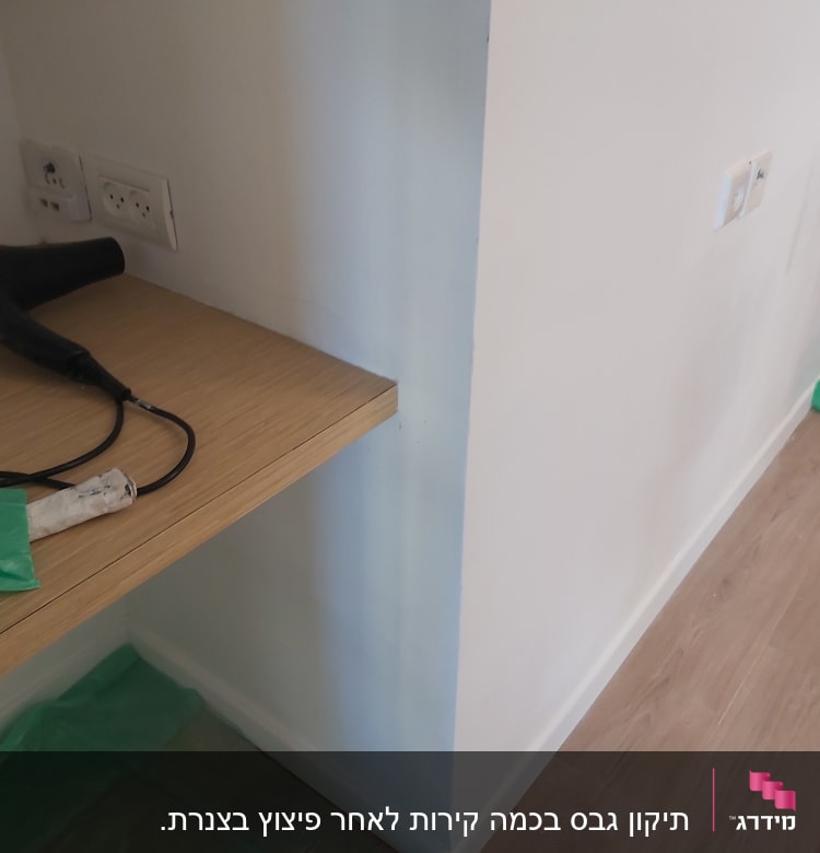 מדף עץ עם מייבש שיער ובקבוק פלסטיק